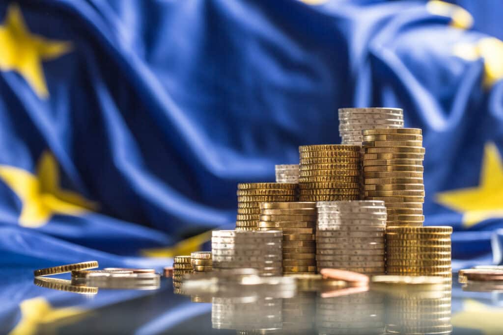 Towers with euro coins and flag of European Union in the background